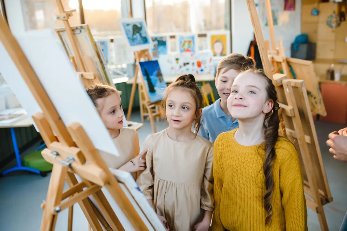 Children painting at easels in the art room