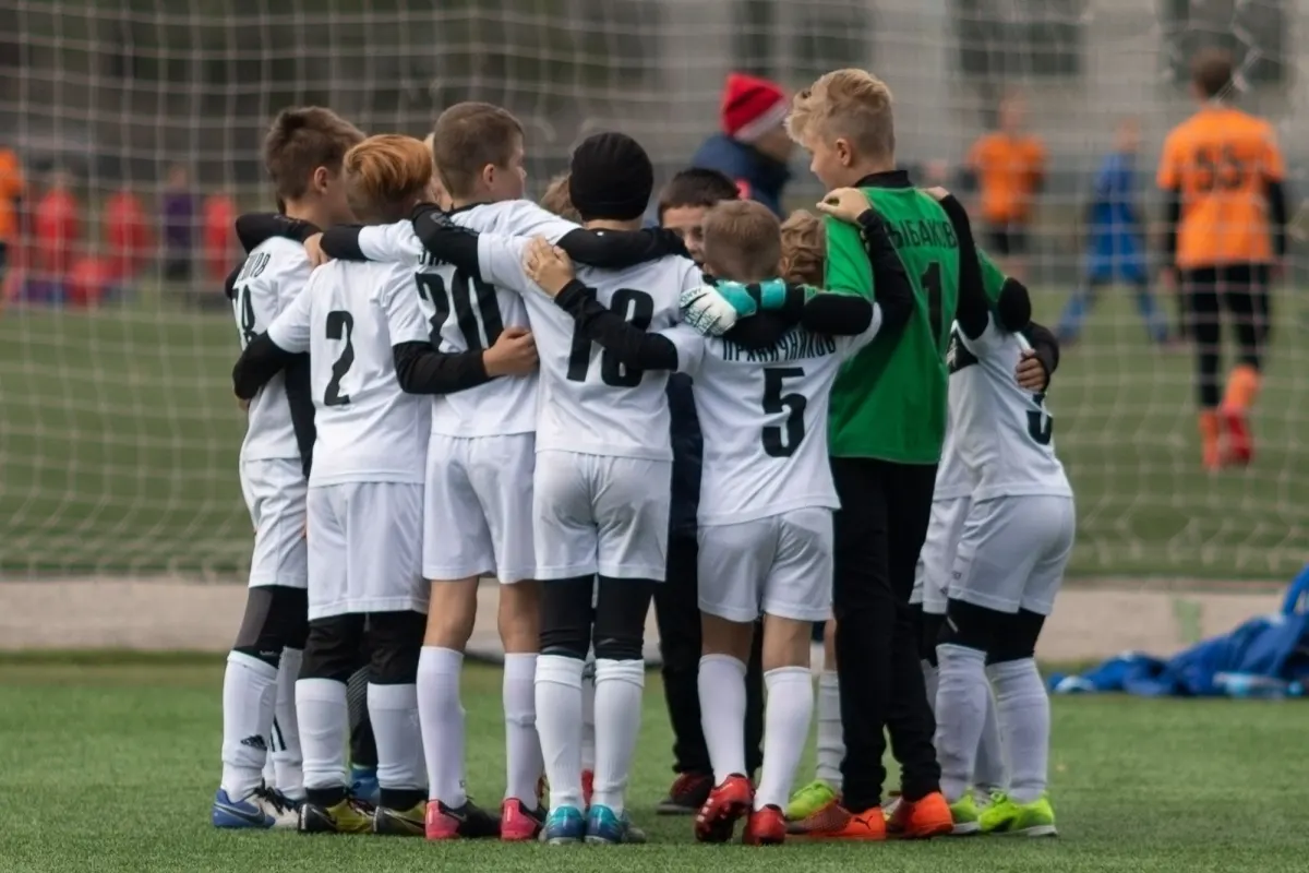 A junior football team in a huddle before a match