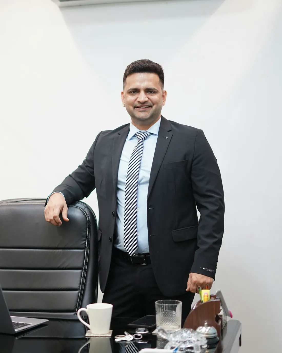 The principal standing beside his desk